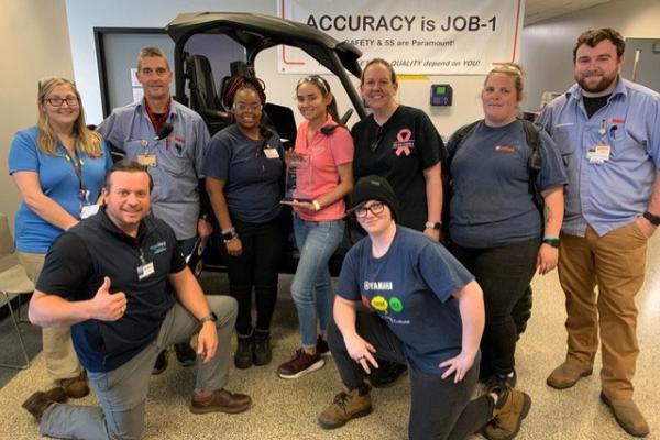 The Yamaha Ergonomics Class graduates learned effective ways to apply ergo to increase safety and efficiency on the assembly line. They include from left to right: Anne Mecke, Chris Taylor, Hadiya Harden, Lenn Casterline, Angela White, Emily Gregory, Drew Hood. Kneeling: Brock Anderson (instructor), Jennifer Winkles. Graduates not pictured: Billy Mcglamory, Victoria Karakos, Cameron Coker